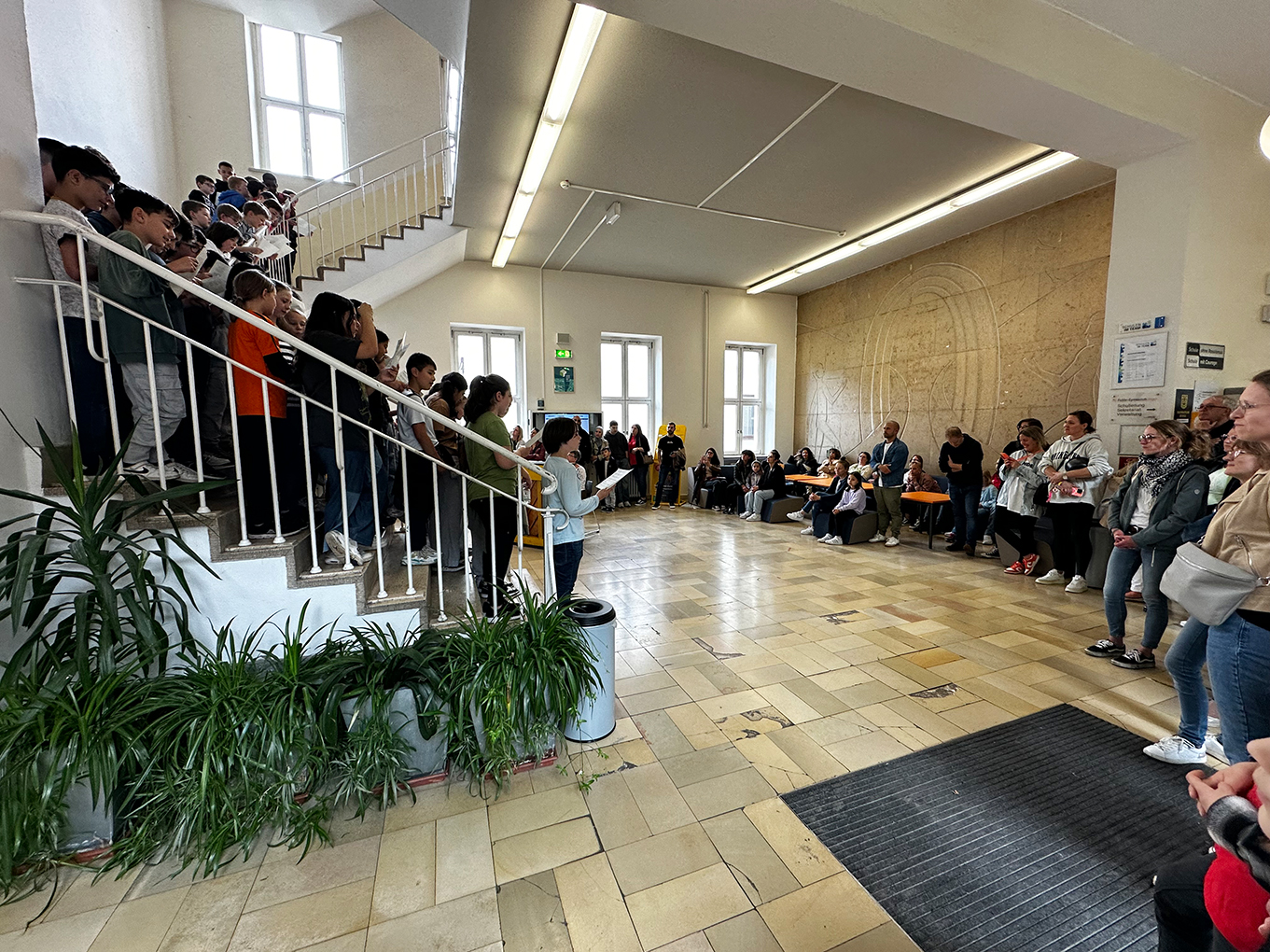 Jugendliche und Erwachsene stehen im Schul-Treppenhaus