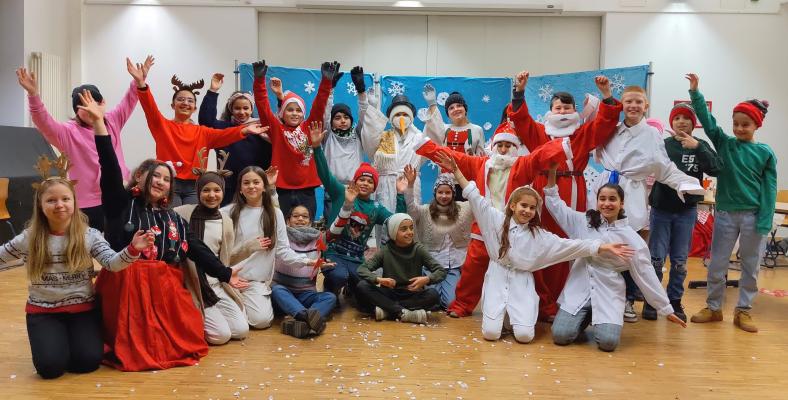 Die Klasse 5c nach der Aufführung ihres Theaterstücks in Kostümen und vor winterlicher Kulisse.