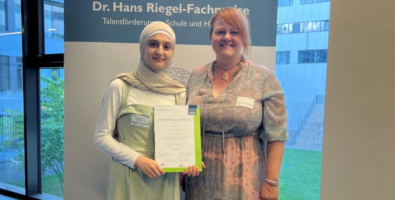 Stolz präsentiert Eilaf gemeinsam mit Frau Thißen ihre Urkunde.