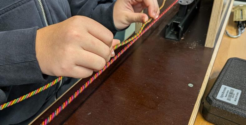 In der Produktionsabteilung werden Armbänder aus Aluminium in den Farben pink, orange und schwarz hergestellt.